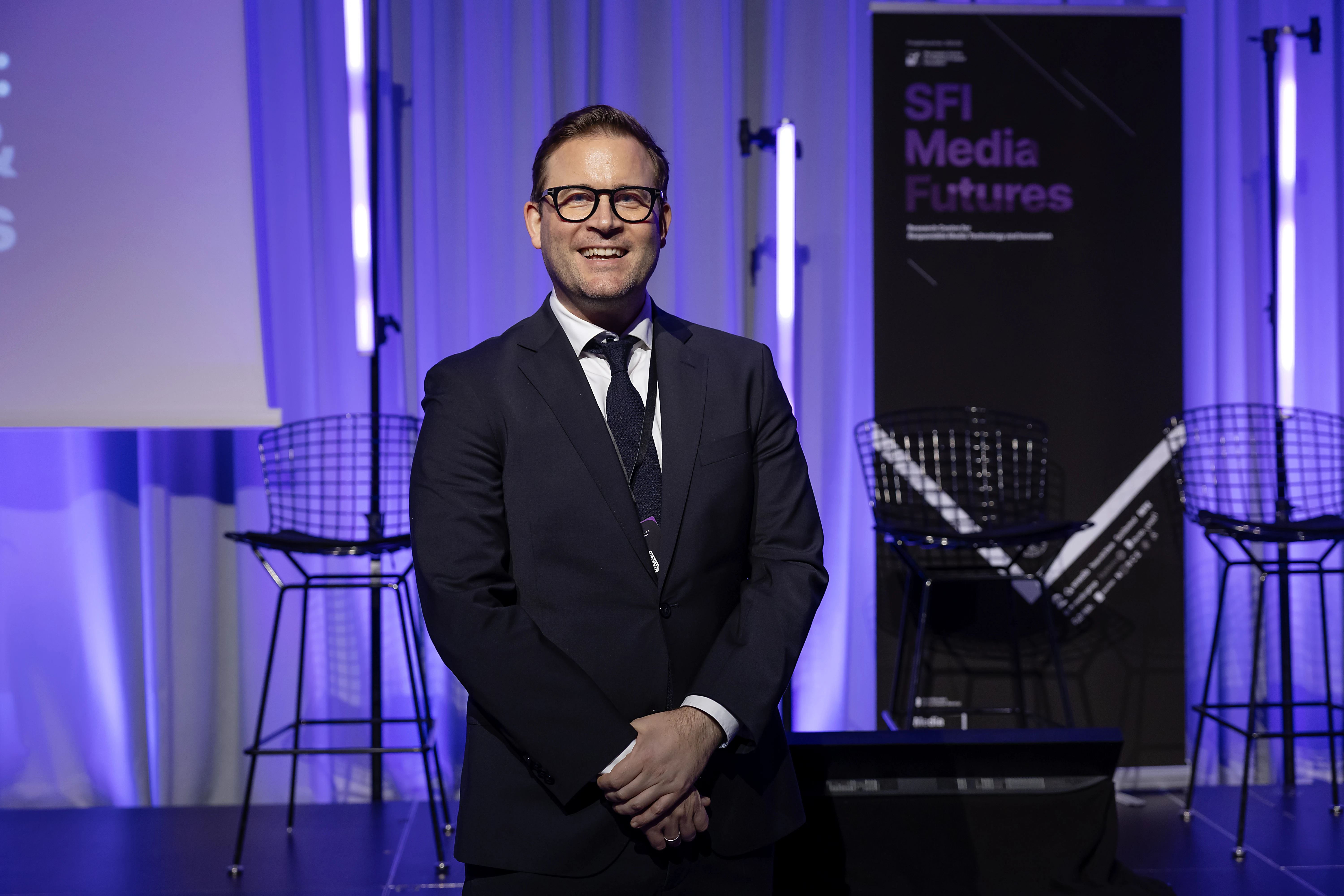 Christoph Trattner smiling on stage with the MediaFutures backdrop.